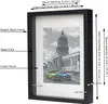 A black shadow box picture frame with a cream mat and a black and white photo of a building and cars. Produktbild-Vorschau