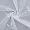 A close-up view of white sheer fabric with embroidered leaf patterns, folded and swirled. Produktbild-Vorschau