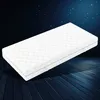 A white mattress is shown on a dark wooden floor against a dark blue starry sky. Produktbild-Vorschau