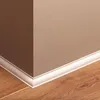 A corner of a room showing a wooden floor and two walls meeting at a right angle, with white baseboard trim. Produktbild-Vorschau