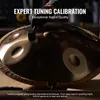 A close-up shot of a handpan being tuned by a person wearing gloves. Náhled obrázku produktu