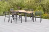 A garden dining set with a table and chairs on a patio, surrounded by lush greenery and flowers. Náhled obrázku produktu