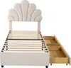A beige upholstered bed frame with a shell-shaped headboard and two open drawers on the side. Produktbild-Vorschau