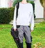 A person holding a leaf blower in a yard. Produktbild-Vorschau