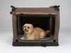 A small, light brown dog is lying inside a brown and black foldable dog crate. Produktbild-Vorschau