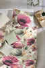 A top-down view of a bed with floral patterned bedding and pillows. Produktbild-Vorschau