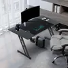 A gaming desk setup in a home office or studio environment, featuring a monitor, keyboard, headphones, and a gaming chair. Náhled obrázku produktu
