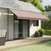 A brown awning is extended over a wooden deck in front of a house. Produktbild-Vorschau