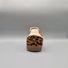 The back view of an Adidas Samba OG sneaker with a leopard print pattern and orange accents. Podgląd zdjęcia produktu