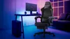 A gaming setup with a desk, computer, and gaming chair, illuminated by colorful ambient lighting. Anteprima dell’immagine prodotto