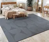 A bedroom scene with a bed, rug, and furniture.