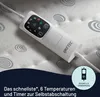 Close-up of a white electric blanket controller with a digital display and buttons, resting on a textured blanket with circular patterns. Anteprima dell’immagine prodotto