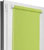 A close-up view of a green roller blind installed on a white window frame. Náhľad obrázku produktu
