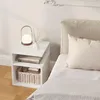A white bedside table with a lamp, diffuser, and books next to a bed. Produktbild-Vorschau