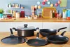 A collection of cookware on a wooden table in a kitchen setting. Produktbild-Vorschau