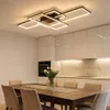 A modern dining room with a large wooden table, chairs, and a contemporary ceiling light. Produktbild-Vorschau