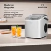 A modern ice maker is shown on a kitchen counter next to two glasses of iced drinks. Produktbild-Vorschau