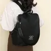 Schwarzer Stoffrucksack mit silberfarbenem ineinandergreifendem Logo, auf dem Rücken einer Person getragen Produktbild-Vorschau