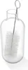 A clear glass milk carafe with a cleaning brush inside, isolated on a white background. Produktbild-Vorschau