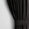 A close-up view of a black velvet curtain with a tie-back. Produktbild-Vorschau