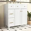 A white bathroom vanity cabinet with gold hardware is shown in a well-lit room with tiled flooring. Anteprima dell’immagine prodotto