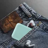 A close-up shot of a pair of blue jeans with a light blue phone case and two white earbuds peeking out of the pocket. Produktbild-Vorschau