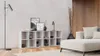 A modern living room with a white cube shelf filled with decorative items, a floor lamp, and a sectional sofa. Produktbild-Vorschau