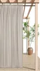 A beige outdoor curtain hanging from a wooden pergola structure. Produktbild-Vorschau