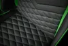 A close-up view of the quilted black upholstery with green stitching on a gaming chair. Náhľad obrázku produktu