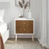 A nightstand with wood-effect drawers next to a bed. Produktbild-Vorschau