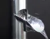 A close-up of a metal scoop with a honeycomb pattern, attached to a silver pipe, with water flowing through it. Produktbild-Vorschau