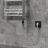 A close-up of a chrome towel warmer element with a digital thermostat and LCD screen, plugged into a wall socket. Náhľad obrázku produktu