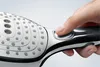 A close-up shot of a hand pressing a button on a shower head. Anteprima dell’immagine prodotto
