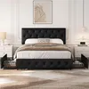 A black upholstered bed with tufted headboard and footboard, featuring two pull-out drawers on each side, set in a bedroom with nightstands and a framed artwork. Produktbild-Vorschau
