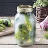 A jar of pickles with dill and garlic on a wooden table. Podgląd zdjęcia produktu