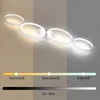 A modern white ceiling lamp with four rings is shown, with a color temperature and brightness slider below. Voir les images du produit