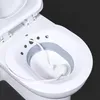 A close-up, overhead view of a bidet attachment for a toilet, showing the seat and the water hose. Produktbild-Vorschau