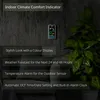 A weather station is mounted on a dark, textured wall next to a large green plant. Text overlays describe its features. Produktbild-Vorschau