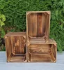 Three wooden crates are arranged in a garden setting with a green hedge in the background. Náhled obrázku produktu