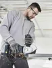 A man is using an angle grinder to cut a metal pipe. Produktbild-Vorschau