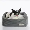 A small dog is lying in a gray dog bed. Náhľad obrázku produktu