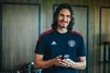 A man in a sports jersey is holding a small electronic device. Anteprima dell’immagine prodotto