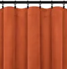 A close-up view of an orange-brown velour curtain hanging from a black curtain rod with clips. Podgląd zdjęcia produktu