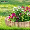 A wooden border filled with colorful flowers and greenery, set in a grassy garden. Produktbild-Vorschau