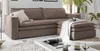 A brown sectional sofa with a chaise lounge and an ottoman in a living room setting. Produktbild-Vorschau