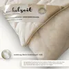 A close-up view of a cream-colored pillow with a label and a small inset showing the filling. Produktbild-Vorschau