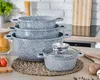 A set of granite-coated pots and pans stacked on a kitchen counter. Anteprima dell’immagine prodotto