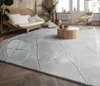 A modern living room with a large rug, sofa, coffee table, and chair. Anteprima dell’immagine prodotto