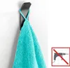 A black wall hook is mounted on a white wall and a turquoise towel is hanging from it. To the right, a graphic indicates that no drilling is required. Produktbild-Vorschau