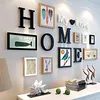 A wall decorated with letters and framed pictures, forming the word 'HOME' and 'My Love'. Produktbild-Vorschau